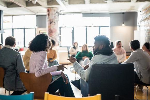 A group of people talking in a conference room